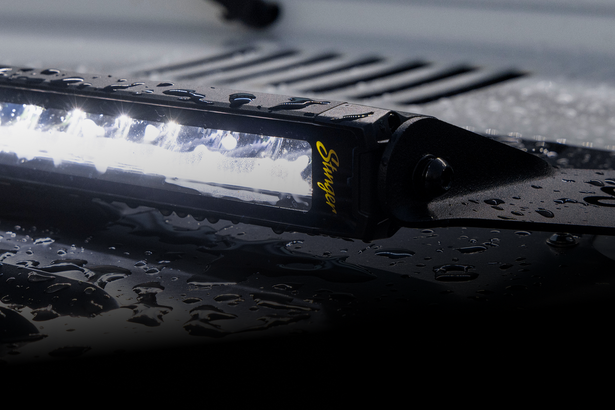 Stinger LED light bar mounted on a vehicle hood with water droplets